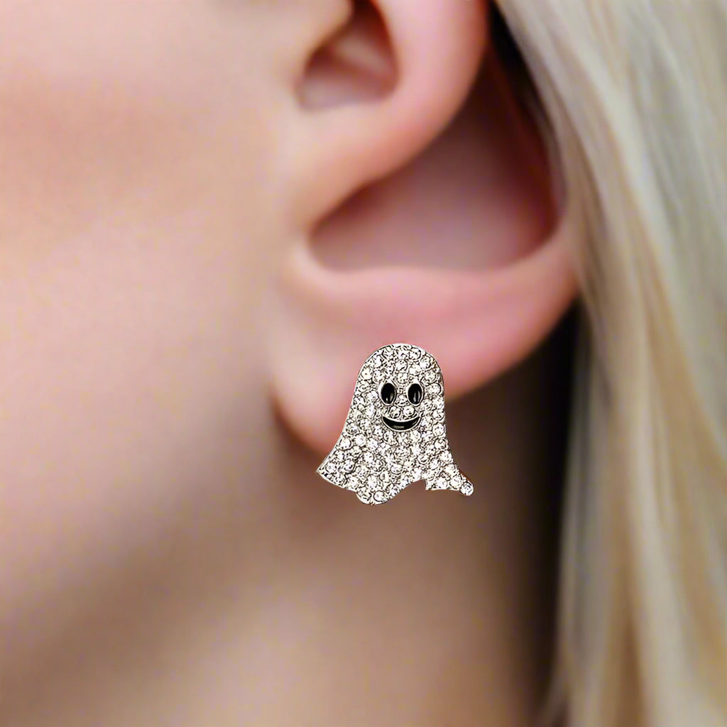 Ghost-shaped earring worn on an ear with a blurred background