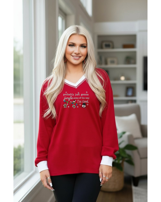 Woman wearing a red long-sleeve shirt with text and graphics in a living room.