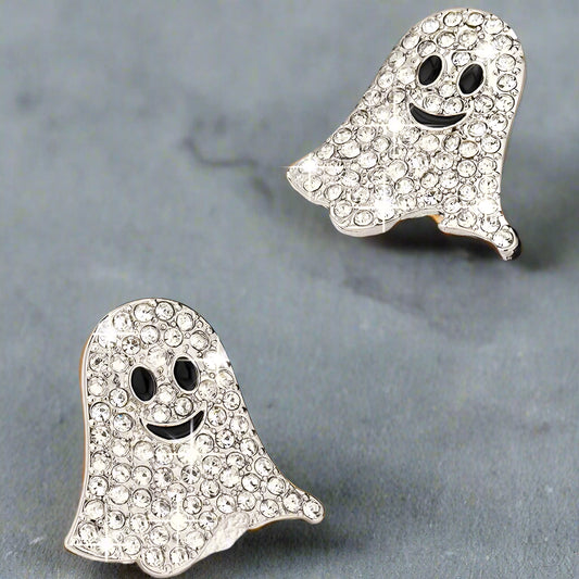 Ghost-shaped earrings with rhinestones on a reflective surface